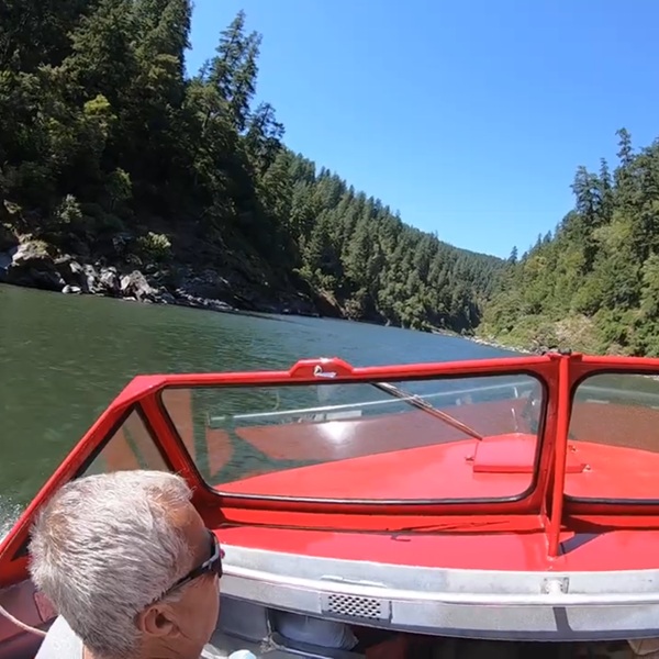 Visitors board large open-air jet boats in Gold Beach before heading upriver through forested canyons, whitewater rapids, and remote wilderness areas inaccessible by normal roads.