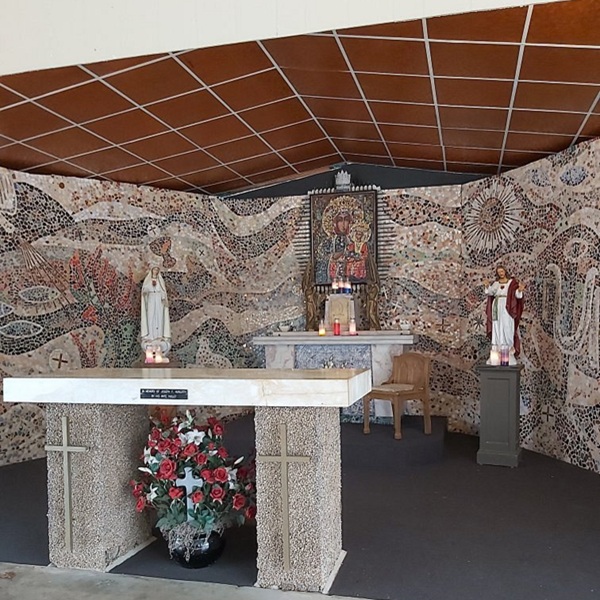 An open-air chapel houses replicas, including a glass-encased painting once touched to the original icon in Poland. 