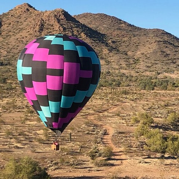 Arizona Balloon Safaris features a bird's-eye view of towering cacti, rugged mountains, and vibrant desert landscapes. 