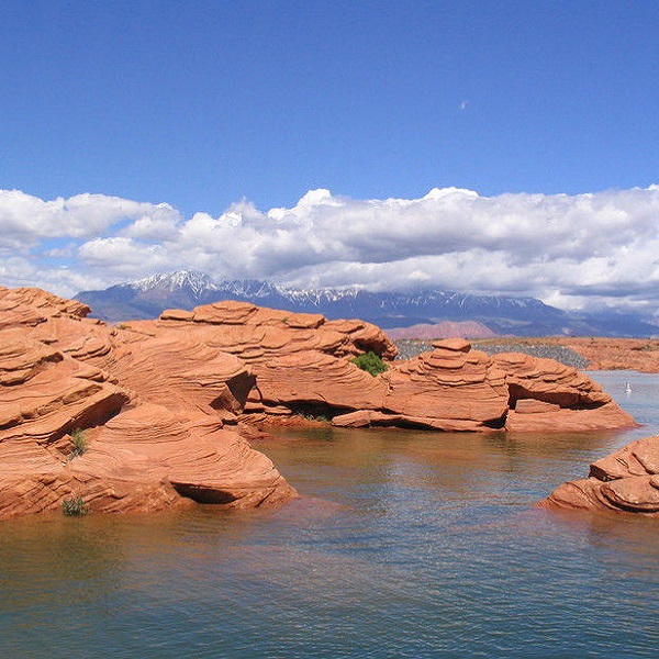 Red rock and red sand meet warm, blue water at Sand Hollow State Park, one of the most popular in Utah. ATV trails run over sand dune access to Sand Mountain in the park, and additional trails are located nearby. 