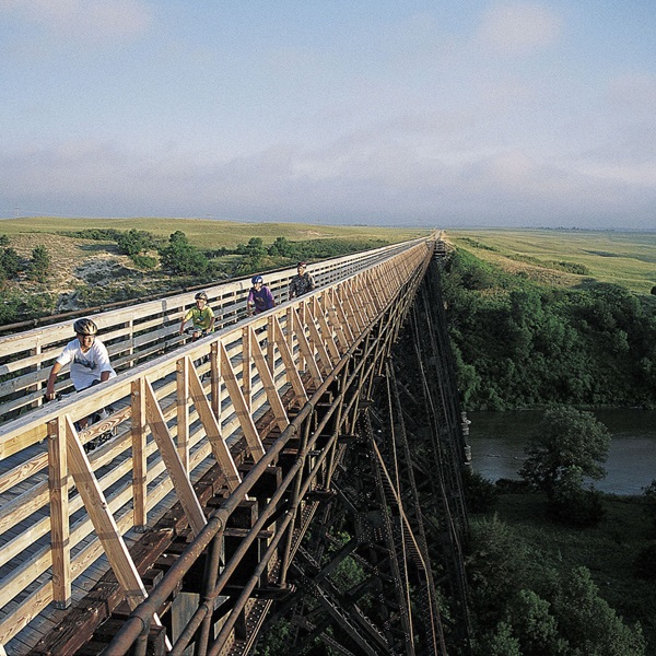 Approaching Valentine, the Cowboy Trail, a rails-to-trails route, crosses the Niobrara River on a historic steel trestle bridge, providing stunning valley views. 