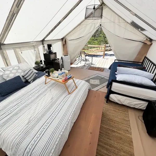 Glamping tents are spacious, fully-furnished tents equipped with comfortable beds, linens, and seating areas, providing a cozy and stylish camping experience.  