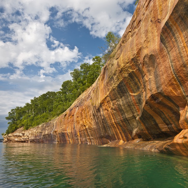 The cliffs are named for their striking colors, including reds, oranges, greens, and blues, created by minerals like iron, copper, and manganese seeping through the rock. 