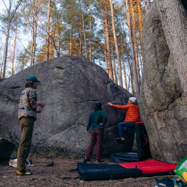 The boulders are spread out in a wooded area, offering a natural and secluded climbing experience. 