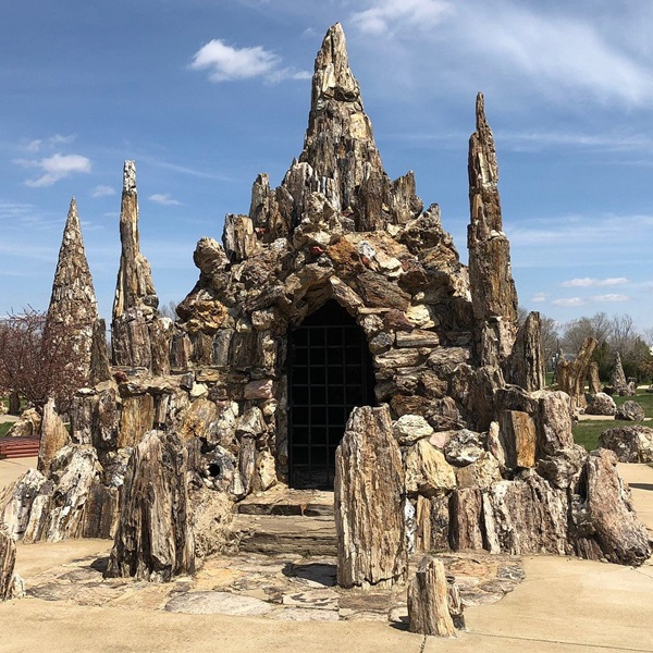 The park features numerous structures made entirely of petrified wood, including towers, pyramids, and a waterfall, with the tallest tower standing over 20 feet high and offering a striking visual centerpiece. 